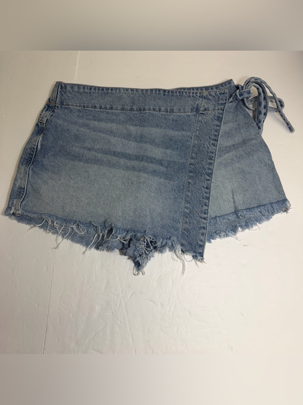 We The Free Light Blue Denim Wrap Shorts with Frayed Hem hole near pocket